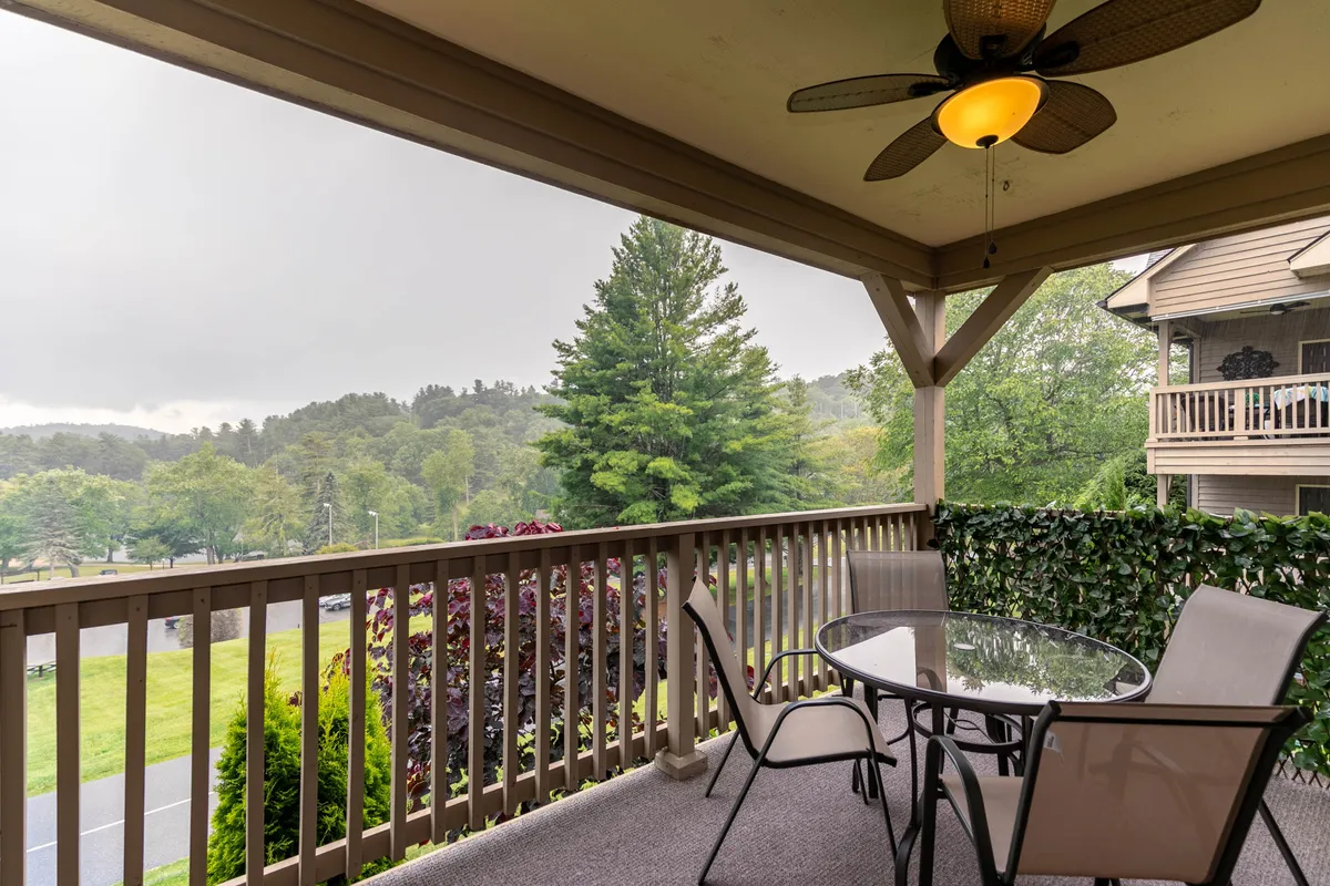 This exterior image captures an inviting outdoor seating area set against a backdrop of lush greenery and sweeping mountain views. The scene suggests a tranquil retreat perfect for morning coffee, reading a book, or simply enjoying the fresh air. Ample natural light bathes the space, and the surrounding landscape connects the home to the outdoors.